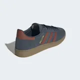Zapatillas Adidas Handball Spezial, color azul con detalles en marrón. Capellada de gamuza, con las tres tiras clásicas de Adidas en los laterales y suela de goma color caramelo.