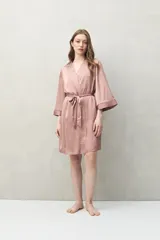 Bata de pijama color rosado, de silueta fluida y estilo envolvente. Confeccionada en tejido satinado con leve elasticidad, con lazo regulable en la cintura y mangas amplias.
