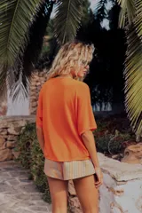 Chaqueta de punto verde con cuello redondo, manga corta y cierre frontal con botones.
