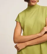 Blusa verde de punto texturizado, con cuello alto acanalado y manga corta amplia.