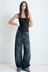 Jeans de tiro medio con corte baggy y bajo acabado en vuelta. Cuenta con trabillas, cinco bolsillos y cierre frontal con cremallera y botón metálico.