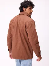 Campera de gabardina negra, con cuello camisero, cierre frontal de cremallera y botones a presión. Posee múltiples bolsillos frontales con solapa y puños ajustables con botones.