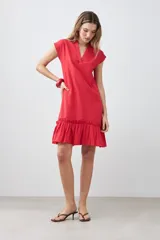 Vestido corto de color rojo con cuello en V, mangas cortas integradas y un detalle de volado en el ruedo. Presenta un diseño de silueta holgada y minimalista.