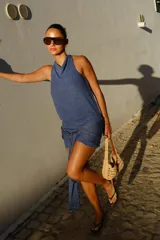 Vestido corto de punto con hilo brillante, escote drapeado, sin mangas y lazo decorativo para atar en la cintura.