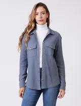 Sobrecamisa de tela texturada tipo waffle, color gris, con cuello camisero, cierre frontal con botones y bolsillos frontales con solapa.