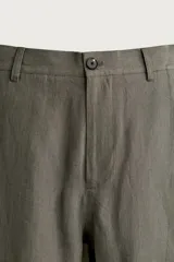 Pantalón straight fit color verde militar, confeccionado en lino, con cintura con trabillas, cierre frontal con cremallera y botón, y bolsillos laterales.
