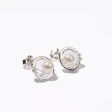 Aros plateados con forma circular, perla central y pequeños brillantes. Cierre a presión.