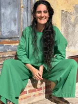 Pantalón tipo palazzo de tiro alto, confeccionado en jersey de algodón color verde. Presenta un diseño amplio con bolsillos laterales y una faja ancha en la cintura que proporciona ajuste y soporte.
