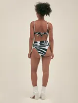 Bikini con estampado abstracto en blanco y negro, compuesto por un corpiño triangular con tirantes finos y una bombacha de talle alto con faja ancha.