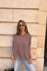 Canguro con capucha de manga larga, color marrón topo, de calce amplio y tejido suave. Presenta bolsillo canguro frontal y puños y ruedo ajustados.