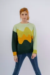 Sweater de lana merino verde con diseño de paisaje abstracto en tonos verde claro, amarillo y naranja.
