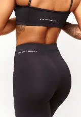 Calza negra de poliamida y elastano, con cintura alta y elástico interno.