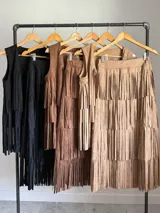 Falda larga de gamuza color marrón, con múltiples capas de flecos largos que le dan mucho movimiento.