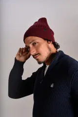 Gorro de lana tejido en punto rib, color bordó, con diseño de doblez en el borde y etiqueta pequeña lateral.