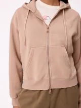 Canguro con cierre frontal y capucha, color gris con efecto desgastado. Presenta bolsillos laterales y logo bordado en el pecho.