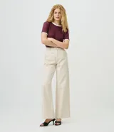 Pantalón wide leg de sarga color beige con estampado a rayas verticales oscuras, de cintura alta con pinzas frontales, bolsillos posteriores y calce amplio.