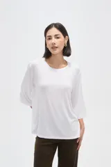 Remera blanca de viscosa con textura acanalada, cuello redondo y mangas 3/4. Presenta un corte holgado y fluido.