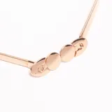 Cinturón elástico dorado, tipo fajín, con cierre frontal compuesto por tres discos metálicos y ganchos ovalados a los extremos.