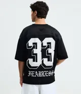 Remera negra de corte boxy y estilo deportivo, confeccionada en tejido de malla de poliéster. Presenta cuello en V, mangas corta, estampado numérico "33" en el pecho derecho y la inscripción "CLUB" en tipografía gótica en el centro.