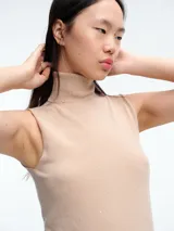 Top sin mangas al cuerpo confeccionado en tejido de viscosa con micro lentejuelas brillantes. Presenta cuello alto y diseño elástico, ideal para diversas ocasiones.