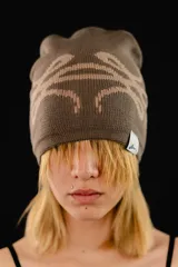Beanie tejido reversible de algodón, con diseño gráfico abstracto en contraste. Presenta una etiqueta con logo en el borde inferior.