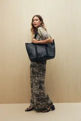 Pantalón ancho de viscosa con estampado a rayas verticales blancas sobre fondo negro, cintura elastizada y caída fluida.