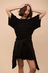 Remerón negro de algodón con textura, corte recto y suelto, manga corta y cuello a la base. Tiene lurex para dar brillo.