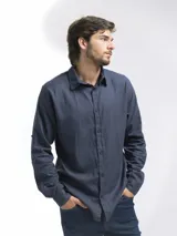 Camisa de manga larga, color blanco, con cuello camisero y botones frontales. El tejido presenta una textura visible de lino.