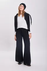Pantalón de punto negro de corte ancho y tiro medio, con cintura elástica y cordón ajustable.
