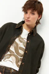 Camisa de jean celeste de manga larga con botones marrones.