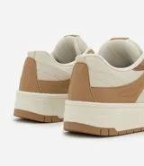 Championes de caña corta marca Satinato, confeccionados en material sintético tipo cuero (PU). Presentan un diseño de paneles en tonos beige y tostado, con suela de plataforma tipo caja y cierre mediante cordones.