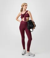 Pantalón legging deportivo Get Over de color bordó, confeccionado en microfibra con cintura alta y pretina ancha. Cuenta con bolsillos laterales y calce ajustado al cuerpo.