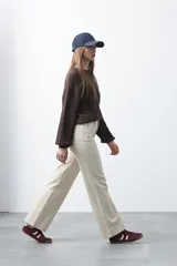 Pantalón de mujer color beige, de corte recto y tiro alto, con costuras frontales marcadas que recorren la pierna.