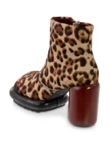 Botín de cuero negro con interior rojo, cierre lateral y tacón cilíndrico de madera color borgoña.