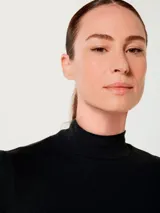 Polera de tela acanalada color marrón, de cuello alto y manga larga.