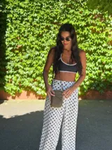 Bandolera compacta color rosado, con correa regulable y desmontable. Tiene apertura superior, bolsillo frontal con cierre y detalle de borla, y bolsillo trasero sin cierre. El interior está forrado en tela y cuenta con un bolsillo adicional.