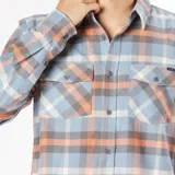 Camisa a cuadros celeste, naranja y gris, de manga larga, con dos bolsillos frontales con botón.