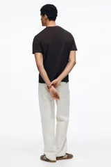 Remera de punto de algodón liviano color marrón oscuro, con cuello redondo ribeteado y bajo recto. Corte estándar para una silueta clásica y cómoda.