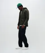 Campera puffer de hombre color verde militar, con capucha integrada, cierre frontal por cremallera y bolsillos cargo frontales. Presenta un diseño acolchado con acabado mate y ajuste en las mangas.