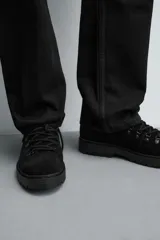 Bota de caña baja con acabado en serraje, horma redonda y suela track con volumen.