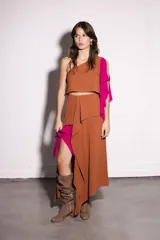 Top marrón de un solo hombro con volado fucsia.