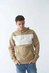 Buzo canguro de felpa color beige con capucha ajustable, bolsillo tipo canguro, mangas largas y arte en relieve en el pecho.