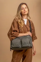 Bandolera de tafeta impermeable color beige, con dos bolsillos frontales con cierre y correa regulable. Diseño práctico y liviano ideal para uso diario.