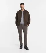 Chaqueta bomber azul marino lisa, con cierre frontal, cuello redondo y bolsillos laterales.