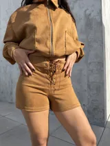 Campera de estilo bomber confeccionada en tejido tipo gamuza scuba, color marrón tostado. Presenta cierre frontal, cuello camisero, puños y ruedo elásticos, brindando un ajuste cómodo y versátil.