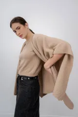 Chaleco color beige de tejido de punto con mangas cortas amplias. Confeccionado en 100% baby alpaca.