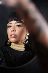 Par de aros colgantes con dije de sol dorado en una oreja y dije de luna plateada con sol en la otra.