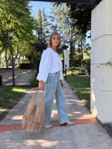 Cartera tipo hobo de cuero color beige con flecos en dos niveles.