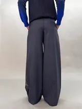 Pantalón de lana azul con estampado abstracto en tonos plateados. Tiro alto, corte amplio y bolsillos laterales ocultos.