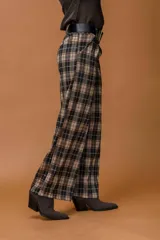 Pantalón de corte ancho y tiro alto con estampado de cuadros en tonos marrones, negros y beige. Presenta pinzas en la cintura y bolsillos laterales.